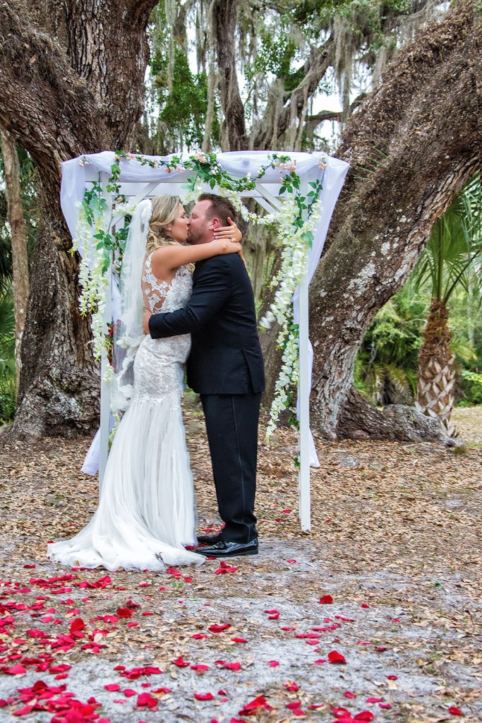 Wedding couple with rose petals by Chris Kovaz